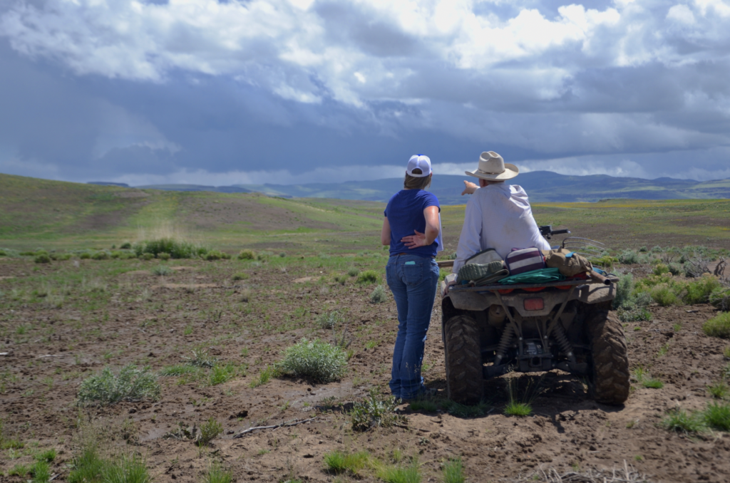 Two people in a wide open rangeland