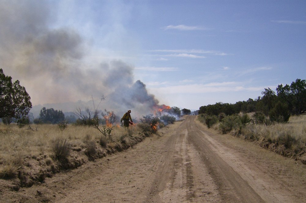 A rangeland fire with a firefighter