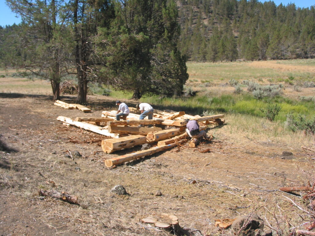 People work on building a log structure.