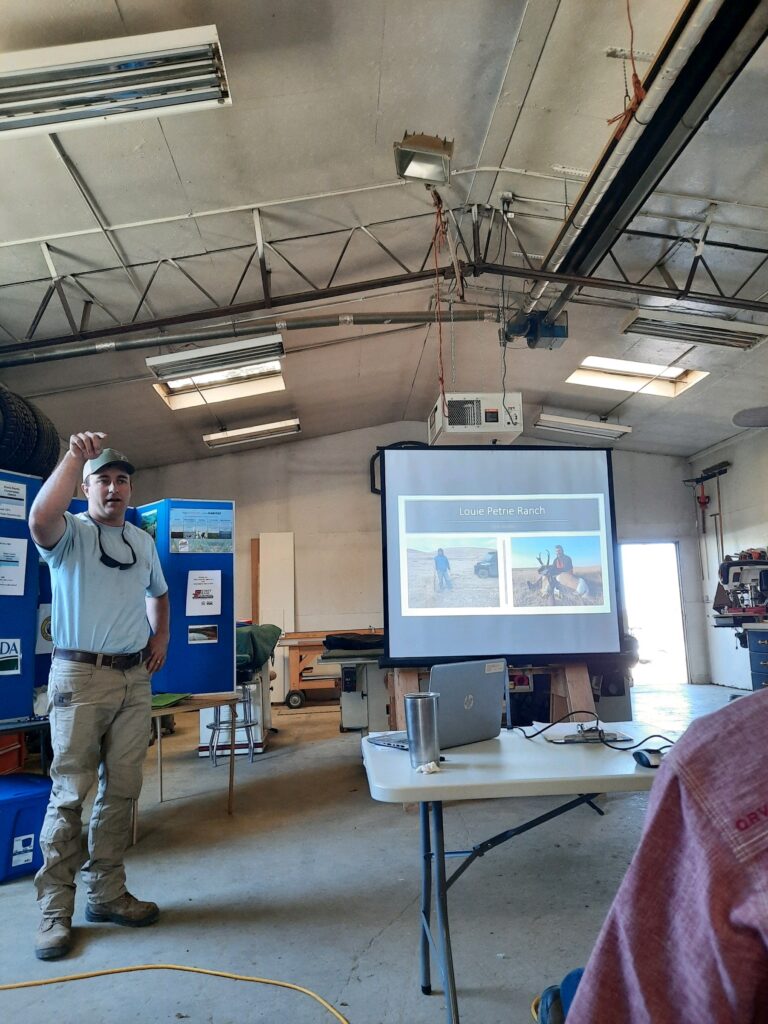 A man gives a presentation inside a warehouse.