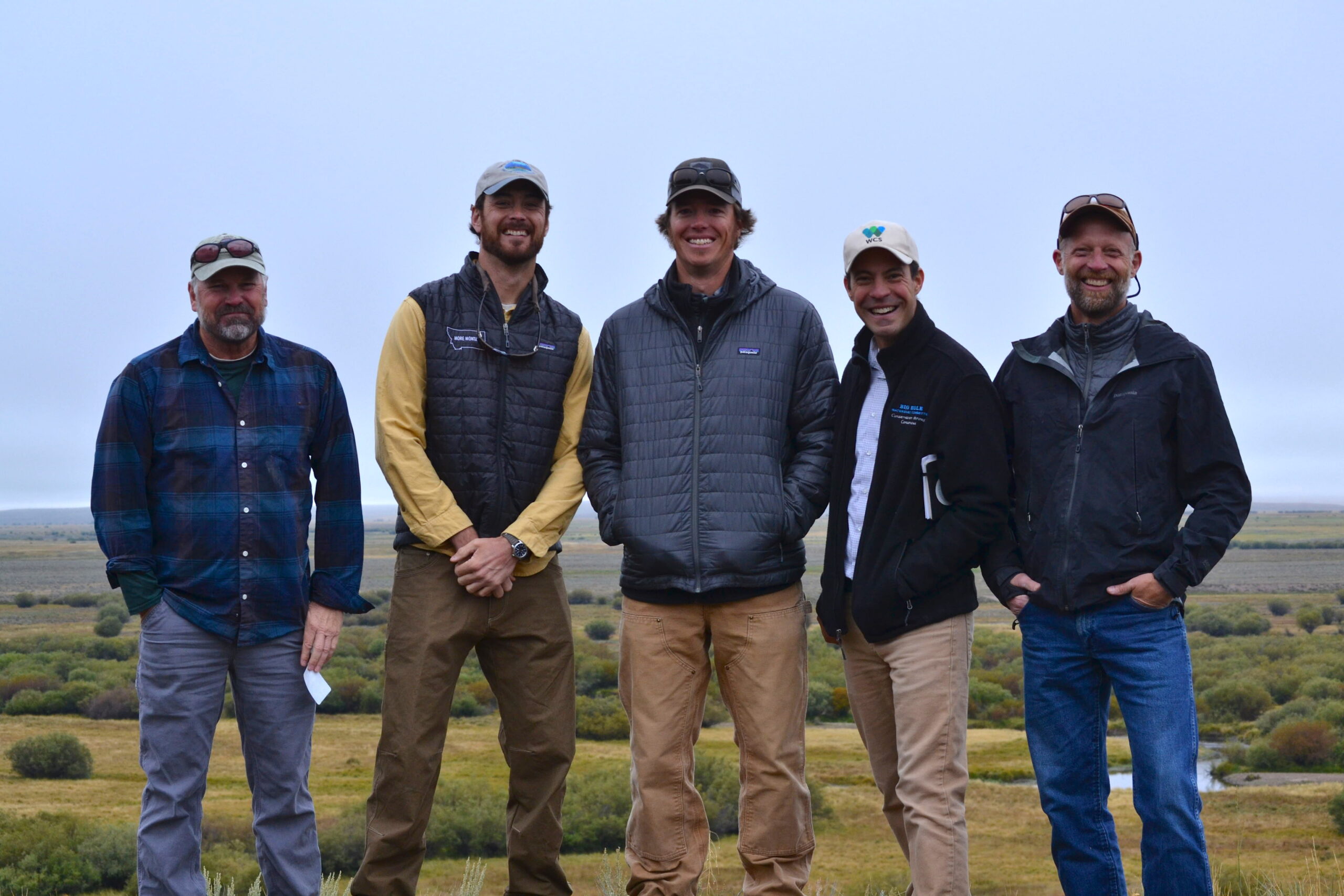 Five men pose for a photo.