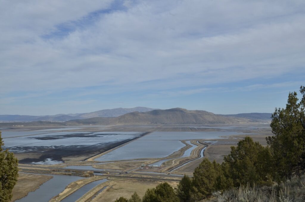 Large flooded fields and canal systems are seen from the top of a hill.