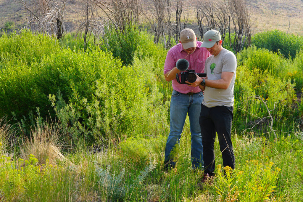 IWJV team members capturing conservation stories in the field with a camera.